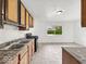 A kitchen featuring white tile flooring, a window, and wood cabinets at 9526 Burrwood Ct, Indianapolis, IN 46235