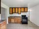 Modest kitchen features wooden cabinets, tile flooring, and a black gas range oven at 9526 Burrwood Ct, Indianapolis, IN 46235