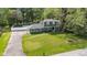 Aerial view of a charming home with a long driveway and lush green lawn at 9860 Sunnymeade Ln, Indianapolis, IN 46280