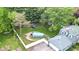 Aerial view of a home with playground, long driveway, green house and fenced backyard at 9860 Sunnymeade Ln, Indianapolis, IN 46280