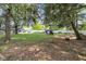Green backyard featuring mature trees and a play set at 9860 Sunnymeade Ln, Indianapolis, IN 46280