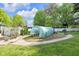 Backyard featuring a greenhouse, well-manicured lawn, and mature trees at 9860 Sunnymeade Ln, Indianapolis, IN 46280