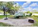 Spacious backyard featuring a basketball hoop, greenhouse, and fire pit at 9860 Sunnymeade Ln, Indianapolis, IN 46280