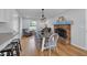 Sunlit dining room features a brick fireplace, wood floors, and stylish lighting fixture at 9860 Sunnymeade Ln, Indianapolis, IN 46280