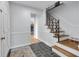 Inviting foyer with staircase, dark slate floors, white trim, and coat closet near the front door at 9860 Sunnymeade Ln, Indianapolis, IN 46280