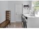 Bright laundry room featuring modern washer and dryer, storage, and neutral decor at 9860 Sunnymeade Ln, Indianapolis, IN 46280