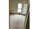 Unfurnished bedroom with worn carpet, window, and doorway at 1014 W 33Rd St, Indianapolis, IN 46208