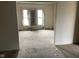 Living room area with a view of three windows, showing torn carpet and dirty space at 1014 W 33Rd St, Indianapolis, IN 46208