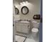 Bright bathroom featuring a white vanity, round mirror, and a toilet with woven basket shelf at 10143 Winslow Way, Fishers, IN 46037