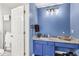 Bathroom featuring blue vanity with marble countertop, modern light fixtures, and white fixtures at 10143 Winslow Way, Fishers, IN 46037