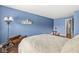 Bedroom featuring light blue walls, hardwood floors, and queen size bed with a white coverlet at 10143 Winslow Way, Fishers, IN 46037