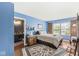 Bright blue bedroom with a plush bed, rich wood flooring, and a connected ensuite bathroom at 10143 Winslow Way, Fishers, IN 46037