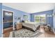 Comfortable bedroom with blue walls, wood floors, a queen size bed, and a full adjoining bathroom at 10143 Winslow Way, Fishers, IN 46037