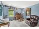 Bedroom featuring light blue walls, a window with a wooded view, and sitting and storage furniture at 10143 Winslow Way, Fishers, IN 46037