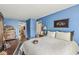 A cozy blue bedroom with hardwood floors, a comfortable queen bed, and an antique dresser at 10143 Winslow Way, Fishers, IN 46037
