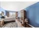 A bright blue bedroom with hardwood floors and an antique cabinet at 10143 Winslow Way, Fishers, IN 46037