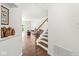 Inviting entryway featuring hardwood floors, staircase, and a glimpse into the living room with a leather sofa at 10143 Winslow Way, Fishers, IN 46037