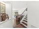 Hallway view leading into the living room with hardwood floors and a staircase with white railings at 10143 Winslow Way, Fishers, IN 46037