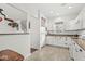Charming kitchen featuring white cabinetry, tiled floors, and a view of the staircase at 10143 Winslow Way, Fishers, IN 46037