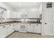 Kitchen with white cabinets, granite countertops, tile flooring, and stainless steel appliances at 10143 Winslow Way, Fishers, IN 46037