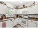 Kitchen with white cabinets, neutral countertop, stainless steel appliances, and a window with natural light at 10143 Winslow Way, Fishers, IN 46037