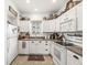 Kitchen featuring white cabinetry, neutral countertops, stainless steel appliances, tile floors, and natural light at 10143 Winslow Way, Fishers, IN 46037
