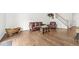 Open living room featuring beautiful hardwood floors, a leather sofa, and a view of the staircase at 10143 Winslow Way, Fishers, IN 46037