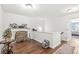 Loft area featuring hardwood floors, white walls, a decorated fireplace, and a door leading to a bedroom at 10143 Winslow Way, Fishers, IN 46037