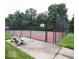 Community tennis court featuring a fenced perimeter and a concrete bench for relaxing at 10143 Winslow Way, Fishers, IN 46037