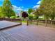 Large wooden deck overlooking a green backyard with a charming picket fence and mature trees, perfect for entertaining at 10305 Lakeland Dr, Fishers, IN 46037