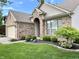 Landscaped front yard featuring a well-maintained lawn, shrubs, and decorative stone at 10305 Lakeland Dr, Fishers, IN 46037
