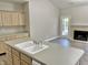 Open concept kitchen offers an island, adjacent living space with a fireplace and outside access, and bright countertops at 10305 Lakeland Dr, Fishers, IN 46037