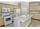 Well-lit kitchen with ample cabinet space, stainless steel appliances, and a central island for food preparation at 10305 Lakeland Dr, Fishers, IN 46037