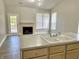 Modern kitchen featuring a double sink, neutral countertops and appliances, and adjacent living space with fireplace at 10305 Lakeland Dr, Fishers, IN 46037