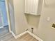 Practical laundry area with overhead cabinets and utility hookups, offering organization and efficiency at 10305 Lakeland Dr, Fishers, IN 46037