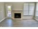 Cozy living room featuring hardwood flooring, a fireplace, and a glass door with windows at 10305 Lakeland Dr, Fishers, IN 46037
