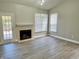Spacious living room with a fireplace, hardwood flooring, and lots of natural light coming from the door and windows at 10305 Lakeland Dr, Fishers, IN 46037