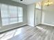 Empty living room with great natural light, neutral walls, and wood-look floors at 10305 Lakeland Dr, Fishers, IN 46037