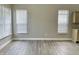 An empty living area featuring hardwood flooring, two windows, and neutral colored walls at 10305 Lakeland Dr, Fishers, IN 46037