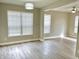 Inviting living room featuring wood-look floors, neutral walls, and abundant natural light from large windows at 10305 Lakeland Dr, Fishers, IN 46037