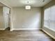Bright room with wood-look floors, neutral walls, chandelier, and large window, offering a versatile living space at 10305 Lakeland Dr, Fishers, IN 46037