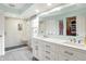 Bright bathroom with dual sinks, white cabinetry, a glass-enclosed shower, and a large walk-in closet at 10310 Foxwood W Dr, Carmel, IN 46280