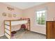 Pink bedroom with a bunk bed, window, and carpeted floor creates a cozy and playful space at 10310 Foxwood W Dr, Carmel, IN 46280