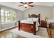 Tranquil primary bedroom features vaulted ceiling, large window, and wooden furniture, creating a serene retreat at 10310 Foxwood W Dr, Carmel, IN 46280