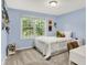 This charming bedroom features soft blue walls, a bright window view, and cozy decor, creating a serene space at 10310 Foxwood W Dr, Carmel, IN 46280