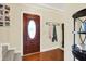 Cozy entryway featuring hardwood floors, a decorative front door with glass, and coat rack on the wall at 10310 Foxwood W Dr, Carmel, IN 46280