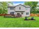 Rear exterior view of a two-story home, showcasing the deck, spacious yard, and landscaping at 10310 Foxwood W Dr, Carmel, IN 46280
