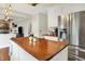Modern kitchen with wooden countertops, white cabinets, stainless steel appliances, and a stylish island at 10310 Foxwood W Dr, Carmel, IN 46280