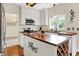 Bright kitchen featuring an island with wooden countertop, white cabinets, and stainless steel appliances at 10310 Foxwood W Dr, Carmel, IN 46280