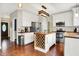 Well-lit kitchen with white cabinets, an island with wine rack, stainless steel appliances, and hardwood floors at 10310 Foxwood W Dr, Carmel, IN 46280